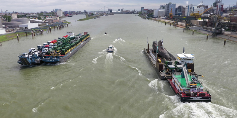 Foto zeigt zwei Großraum- und Schwertransportschiffe auf einer Binnenwasserstraße. Link führt zur Fachdatenbank GST-Umschlagstellen.