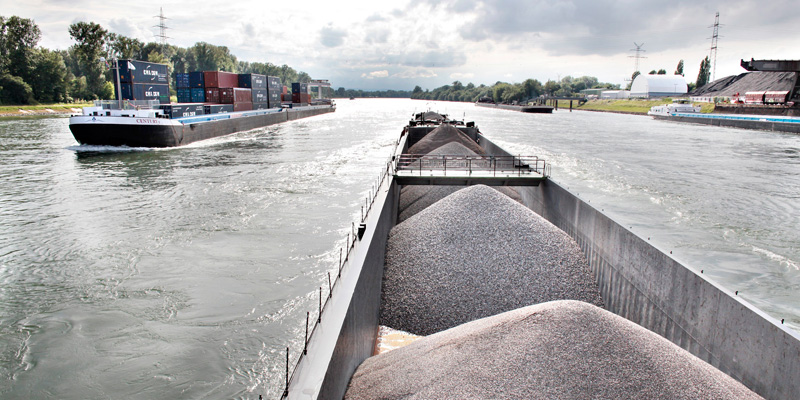 Foto zeigt Transportschiffe auf einem Binnengewässer. Link führt zum System Transportmengen-Visualisierung (TraVis)